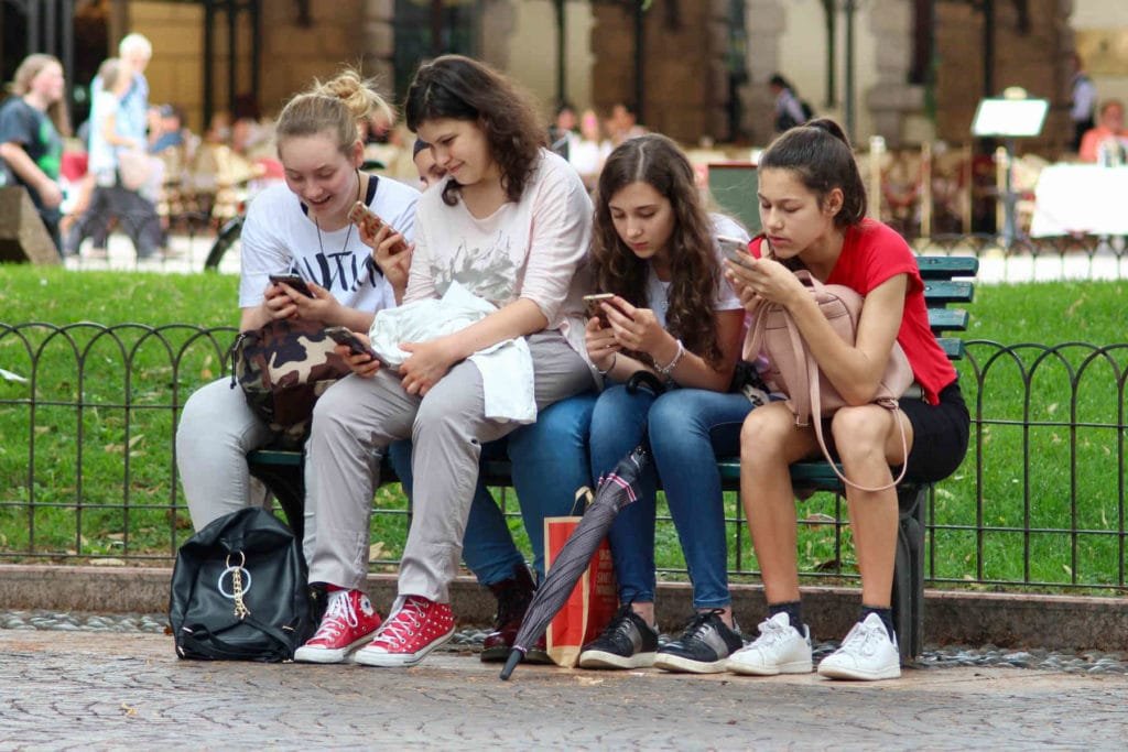 Varias chicas viendo contenido web en celulares y atentas al marketing digital